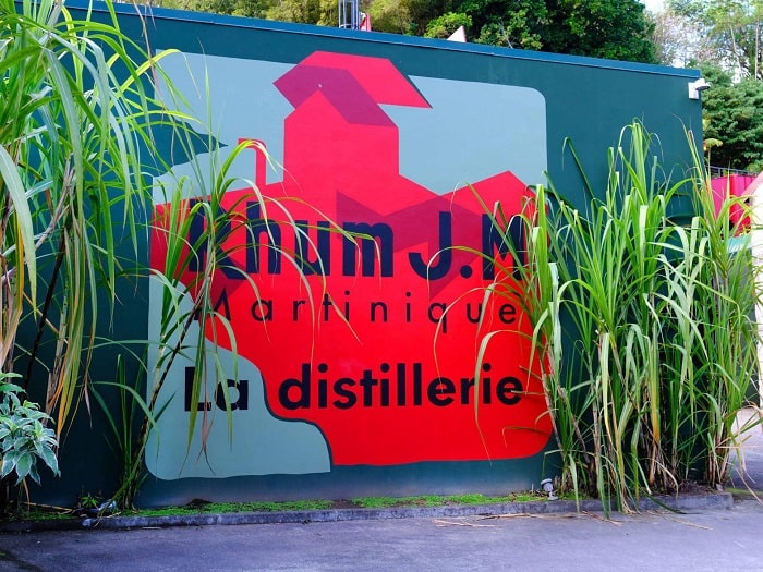 Entrée de la distillerie Rhum J.M entourée de cannes à sucre en Martinique