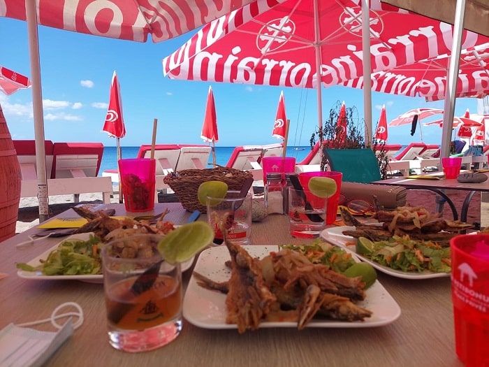 Repas créole servi en terrasse face à la mer au Petibonum