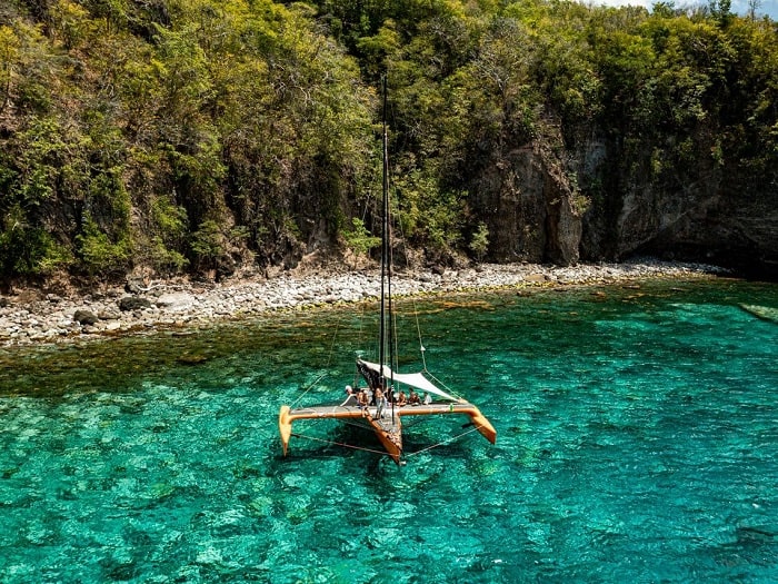 Trimaran Madisail au mouillage dans une eau turquoise en Martinique